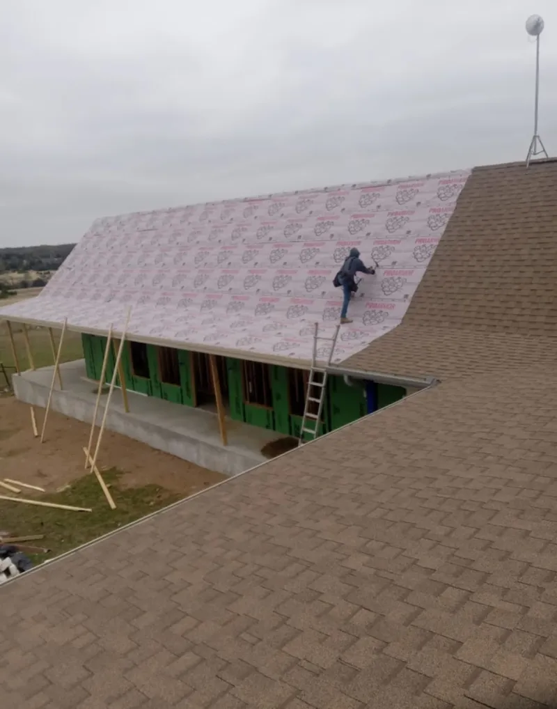Worker preparing underlayment for a metal roof installation in Saddlebrooke